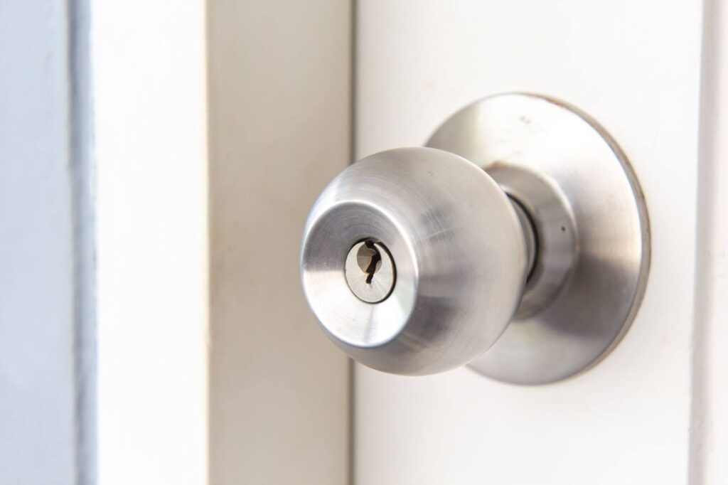  A close-up shot of a silver door knob with a slot for a key in the middle.