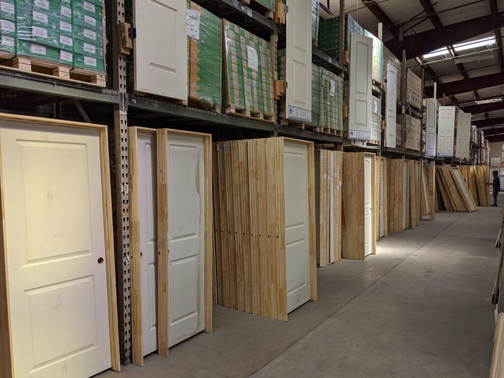 A long line of pre-assembled interior doors at a surplus store.