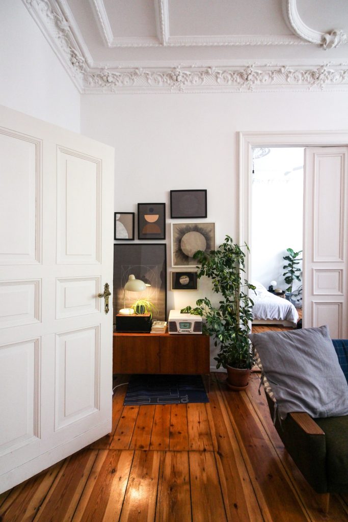 Living room with traditional panel wood doors. Interior pine doors are painted white to contrast darker furnishings.
