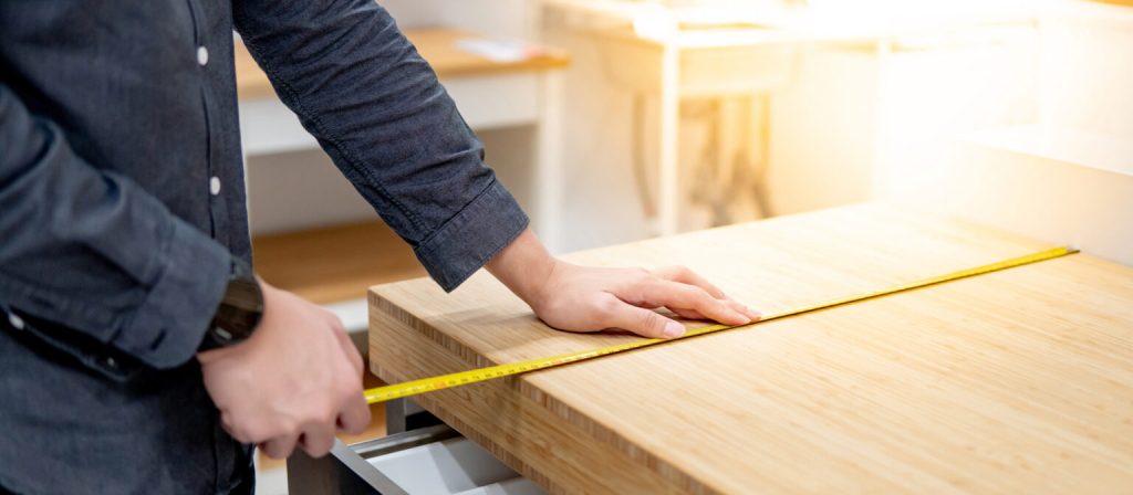 A man taking measures in preparation for installing a kitchen countertop