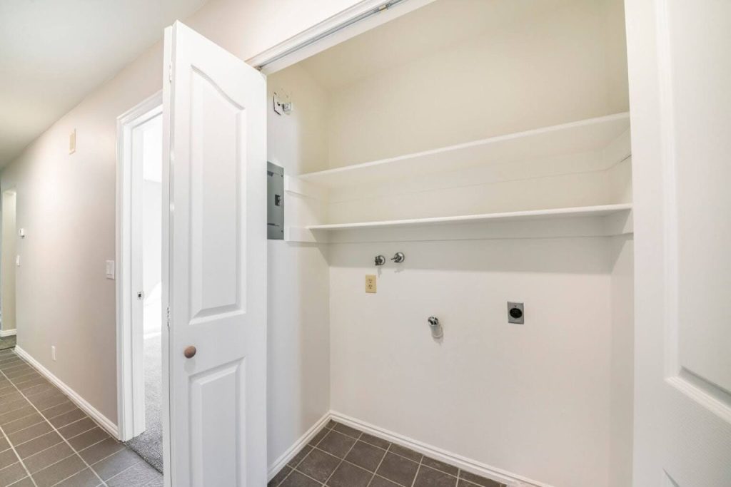 An empty closet with a white bi-fold door