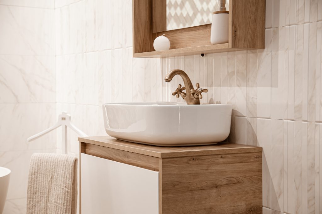Cozy bathroom interior with a beautiful vessel sink and retro faucet.